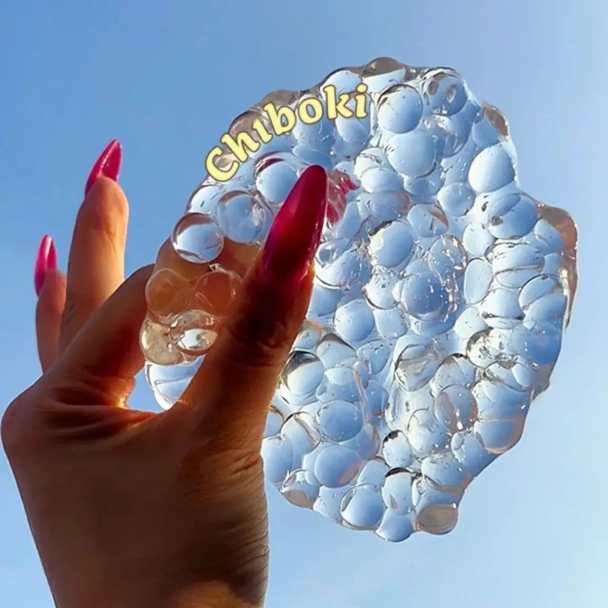 Balle squishy transparente remplie de billes façon boba tenue dans une main