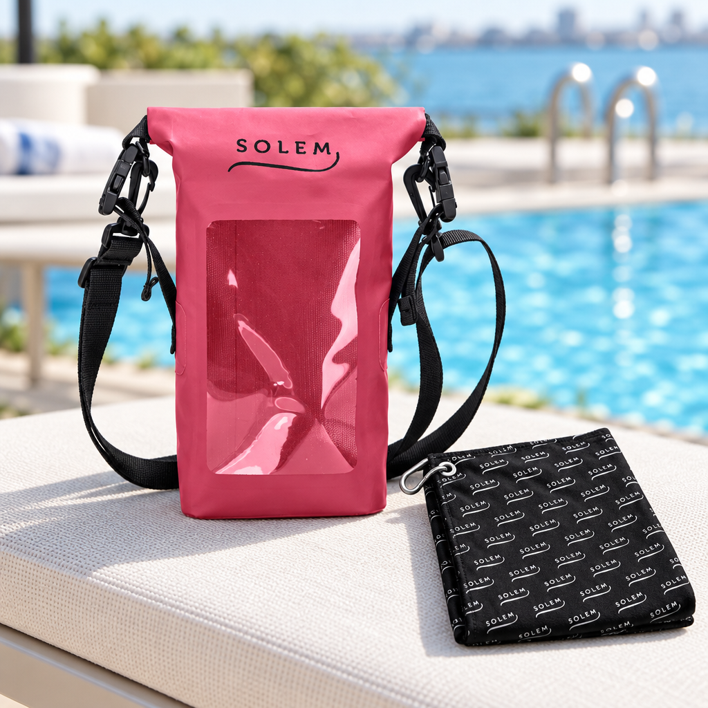 Pochette étanche rose vif SOLEM pour cellulaire et serviette multisport sur un bord de piscine