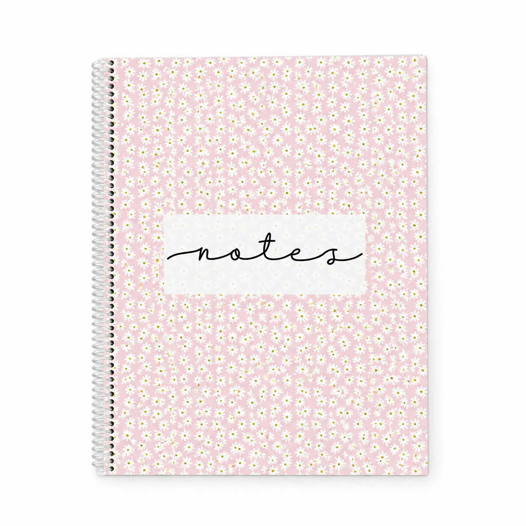 Cahier de notes rose à spirale couvert de petites marguerites blanches sur fond blanc