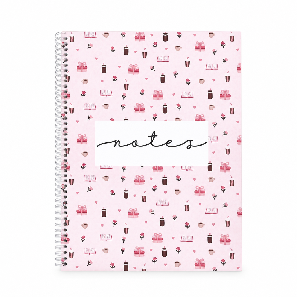 Cahier de notes rose à spirale avec motifs de livres, cafés et roses sur fond blanc