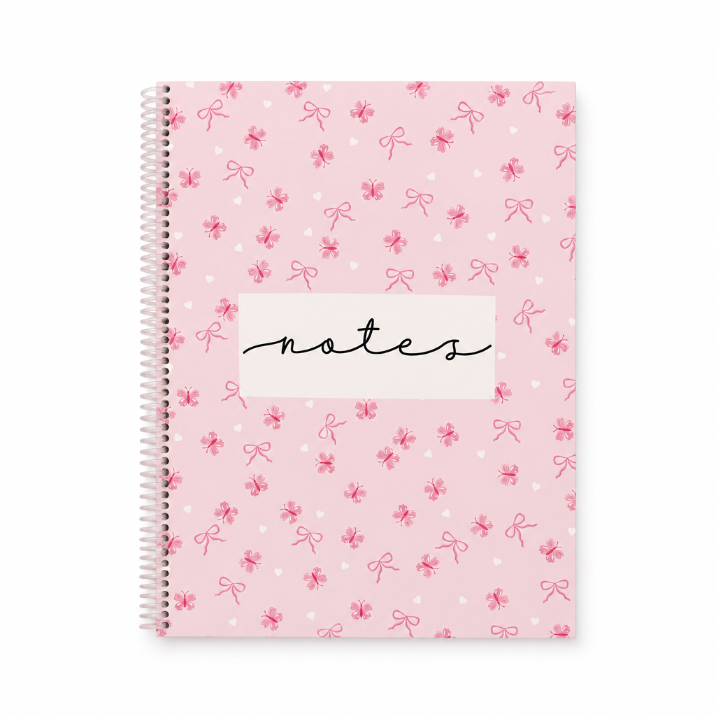 Cahier de notes rose à spirale avec motifs de papillons, boucles et cœurs sur fond blanc