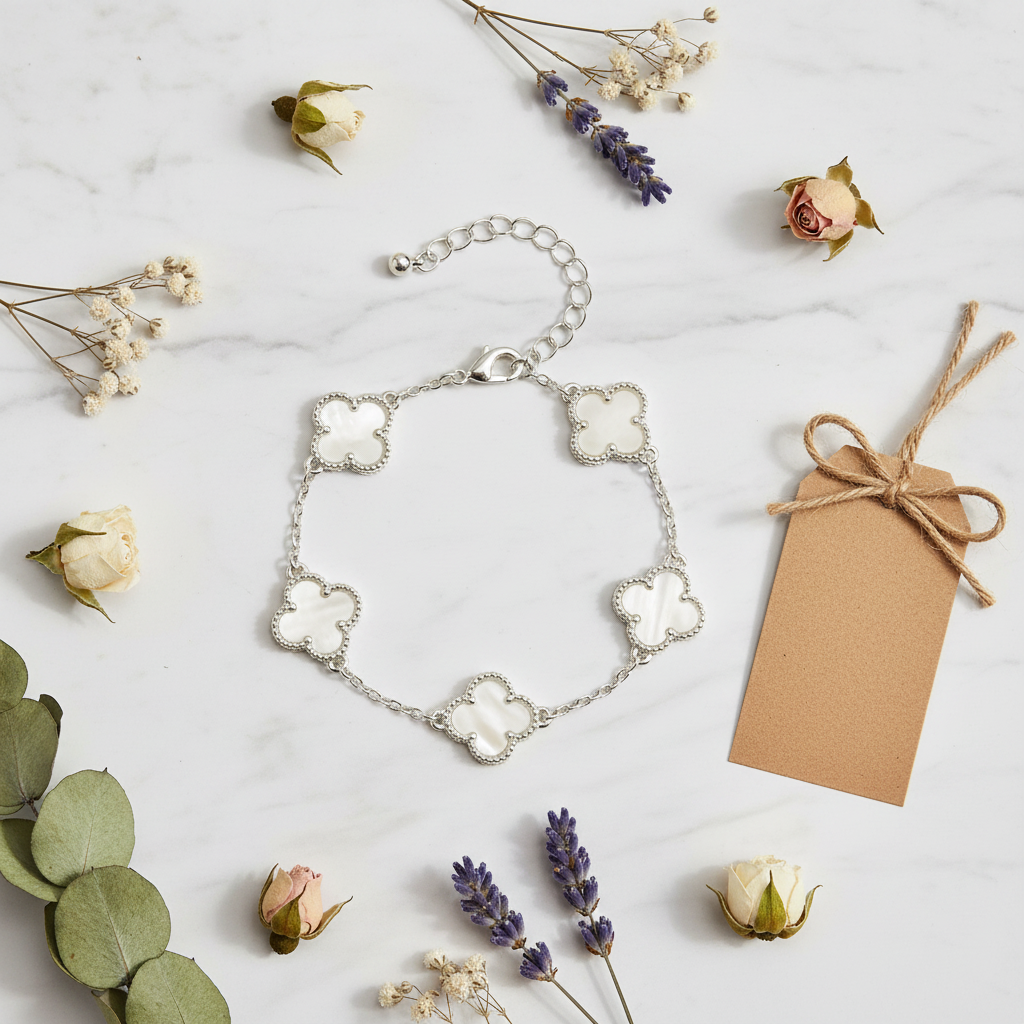 Flat lay bracelet trèfle coquillage blanc argenté sur marbre blanc
