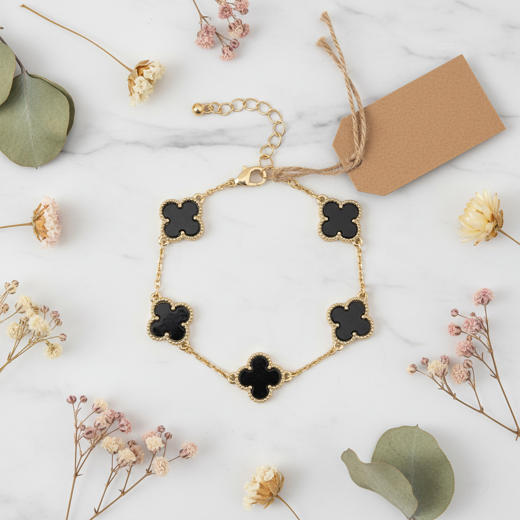 Flat lay bracelet trèfle coquillage noir sur marbre blanc
